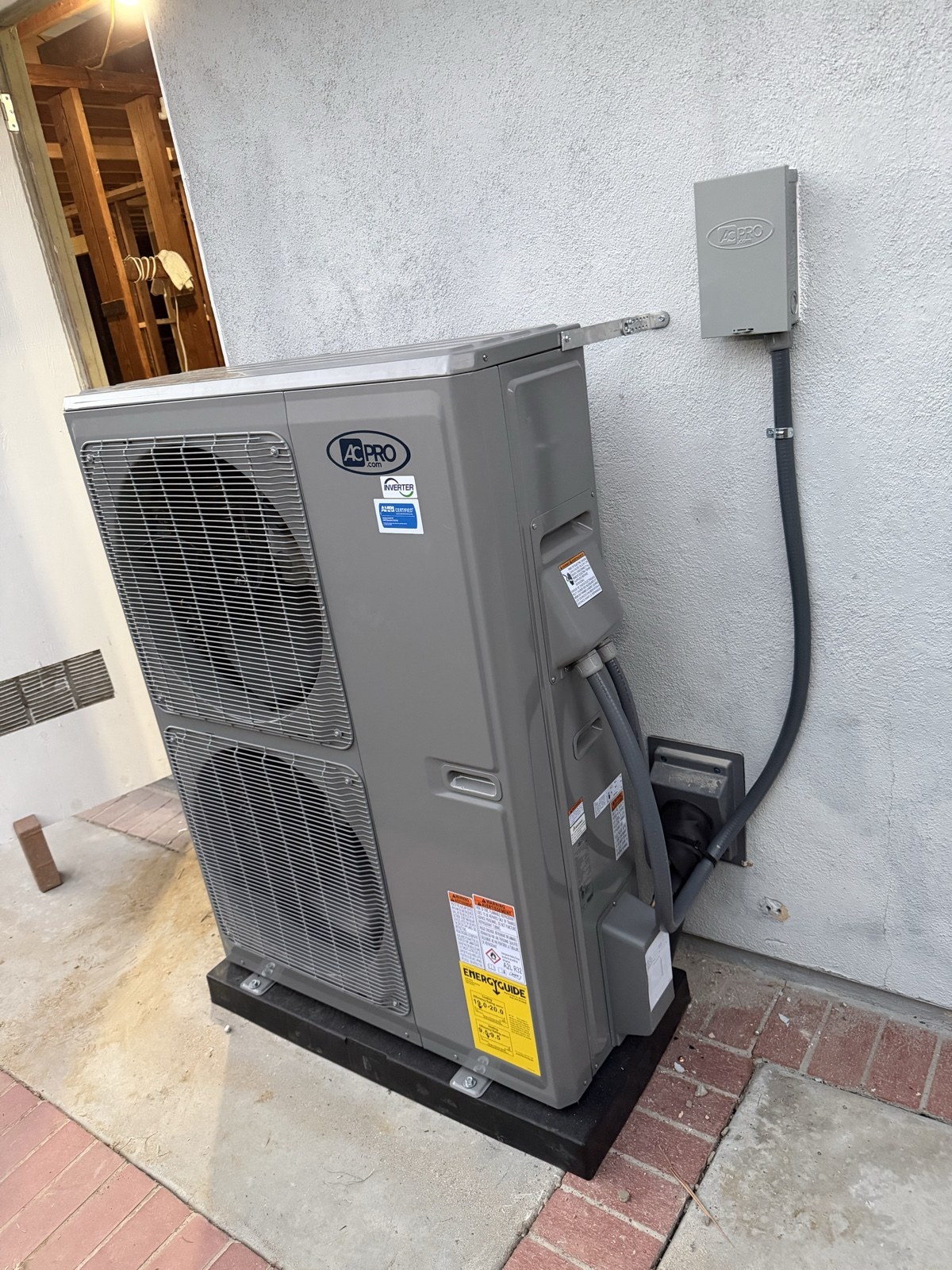 Inverter heat pump outdoor unit installed beside a home