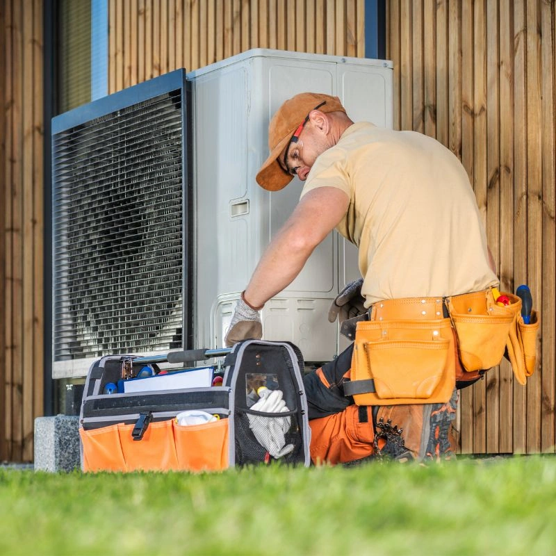 A professional technician installing a high efficiency outdoor heat pump system for a residence in Colton.
